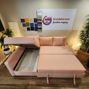Blush pink IKEA Friheten sofa bed fully extended with pull-out sleeper and open storage, custom-upholstered by Grand Jeles.